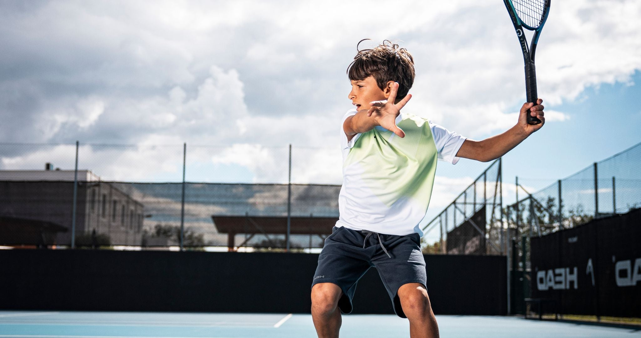 Top Game junior tennis player hitting a strong backhand shot on outdoor court