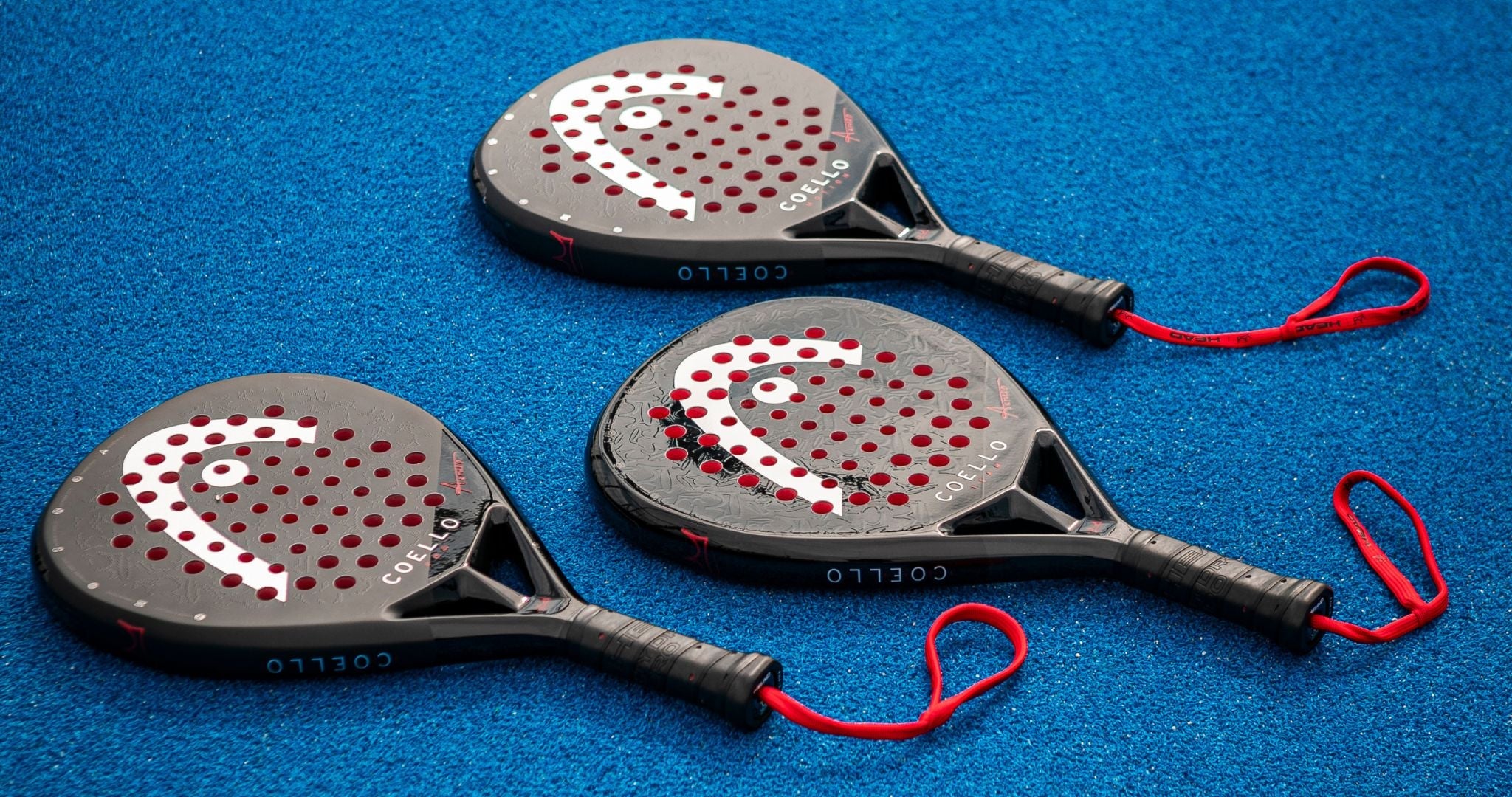 Top Game set of three HEAD padel rackets with red straps on blue court