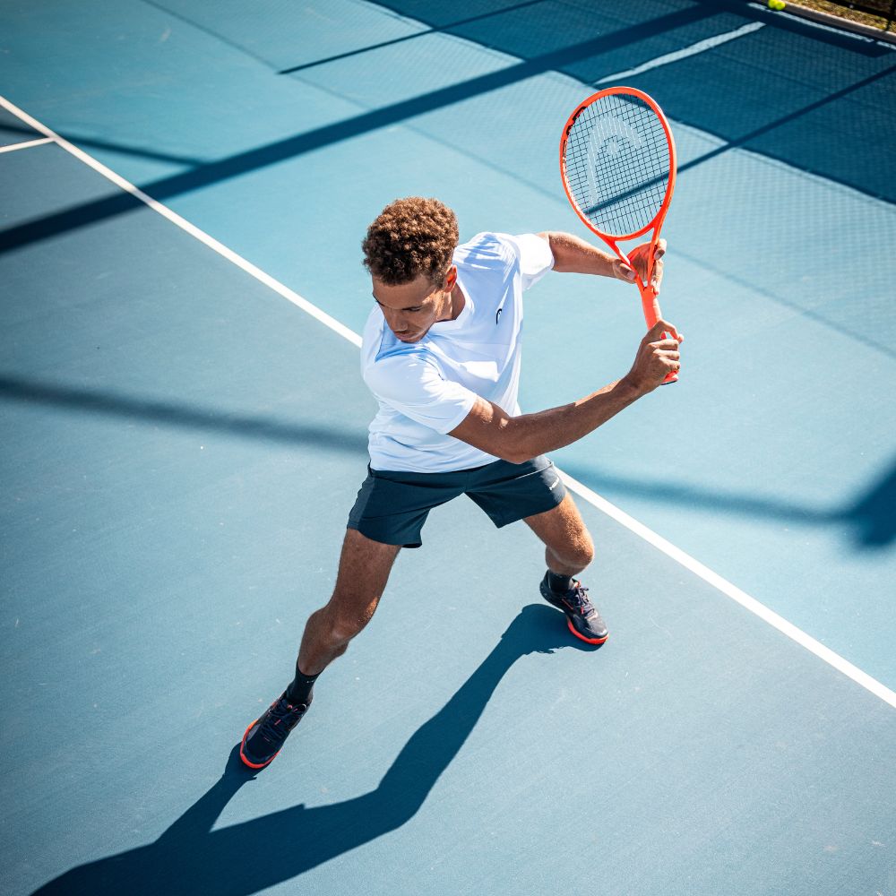 Top Game tennis player preparing backhand swing on blue hard court